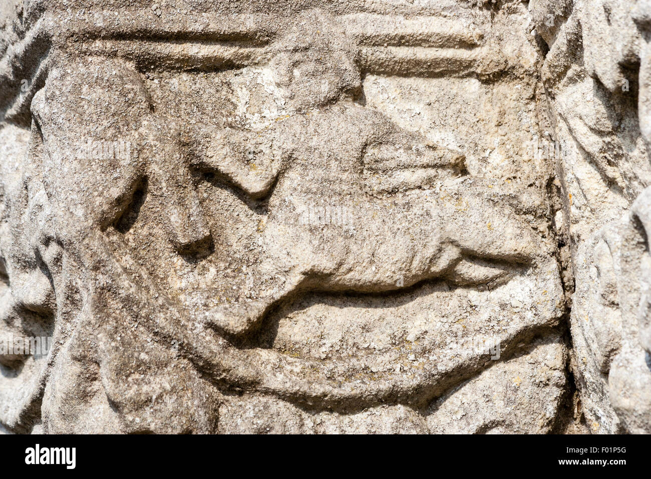 L'Angleterre, Barfrestone. Norman sculptures sur pierre. St Nicholas church. Porte Sud, colonne, un chevalier monté en charge. Close up detail de la sculpture. Banque D'Images