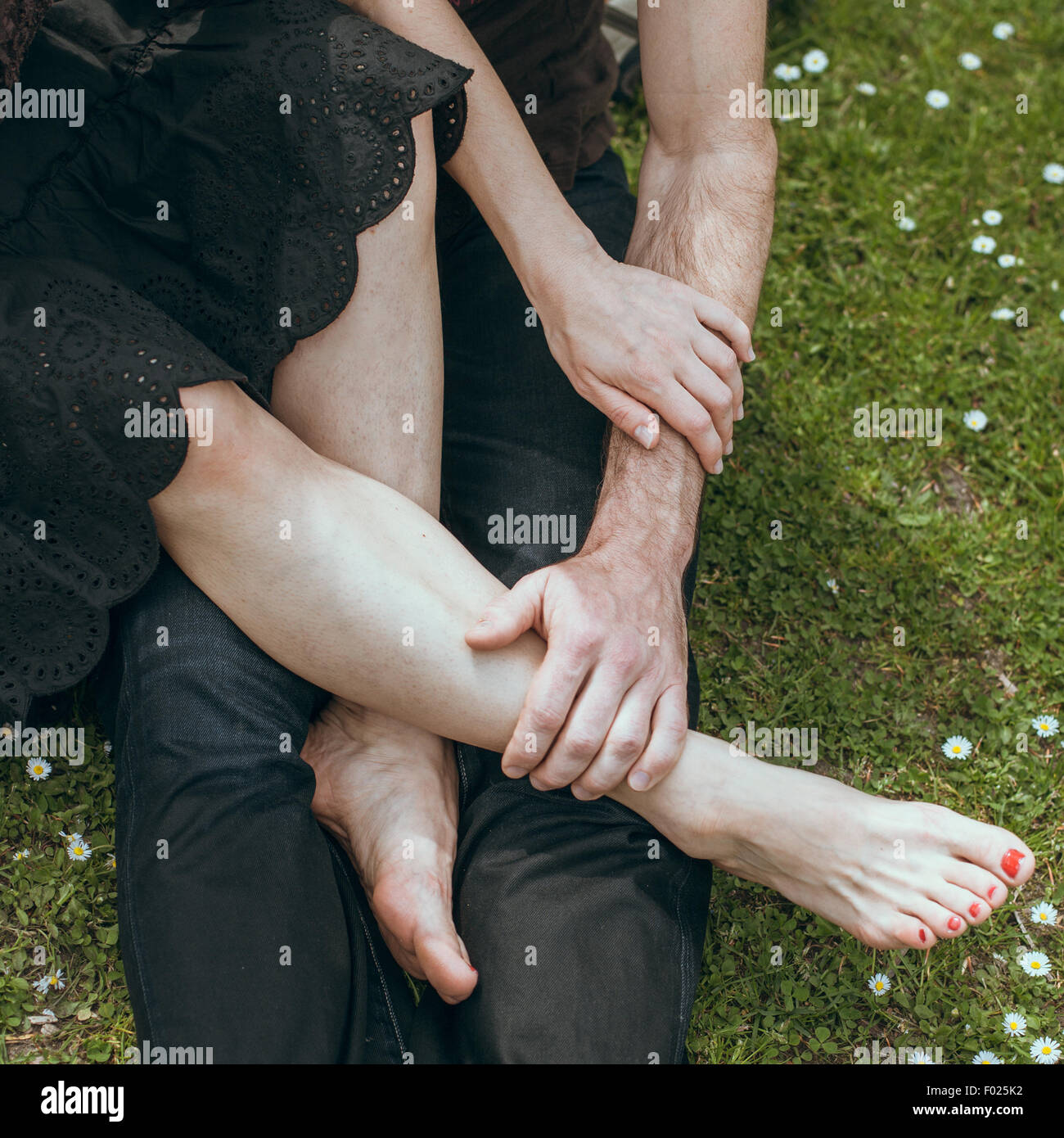 Close up of young man holding a young woman's pieds dans sa main Banque D'Images