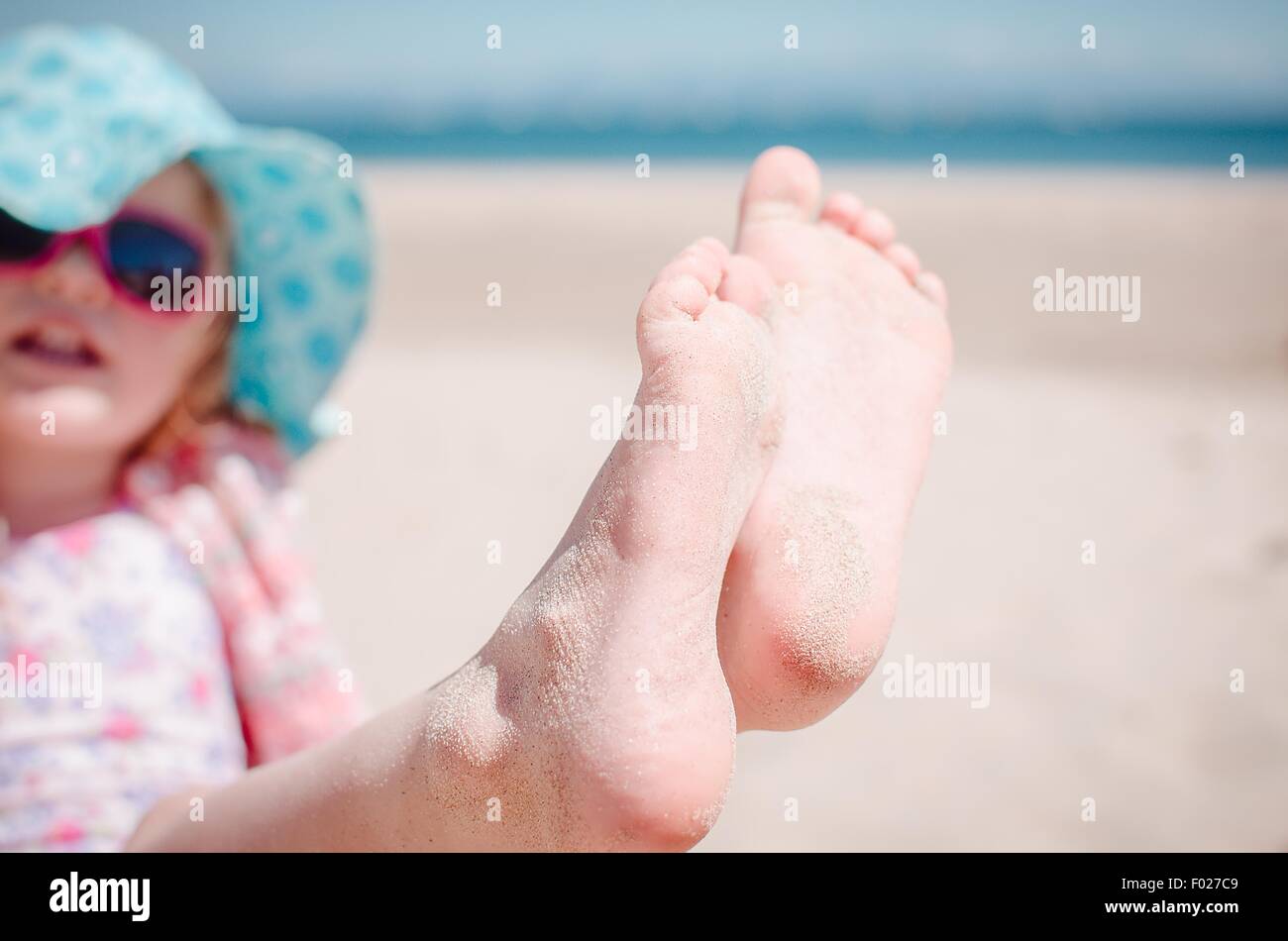 Girl exhibant ses orteils de sable sur la plage Banque D'Images