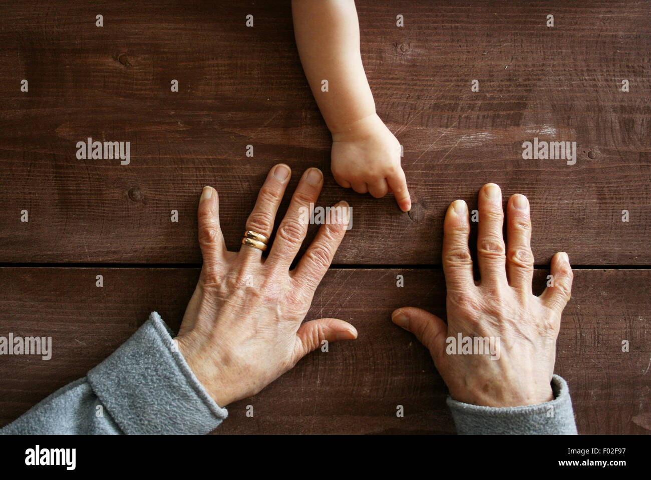 Baby Boy's main pointant à grand-mère. Banque D'Images