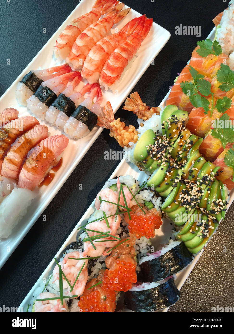 Gros plan d'un assortiment de sushis avec petits pains nigiri et maki californien Banque D'Images