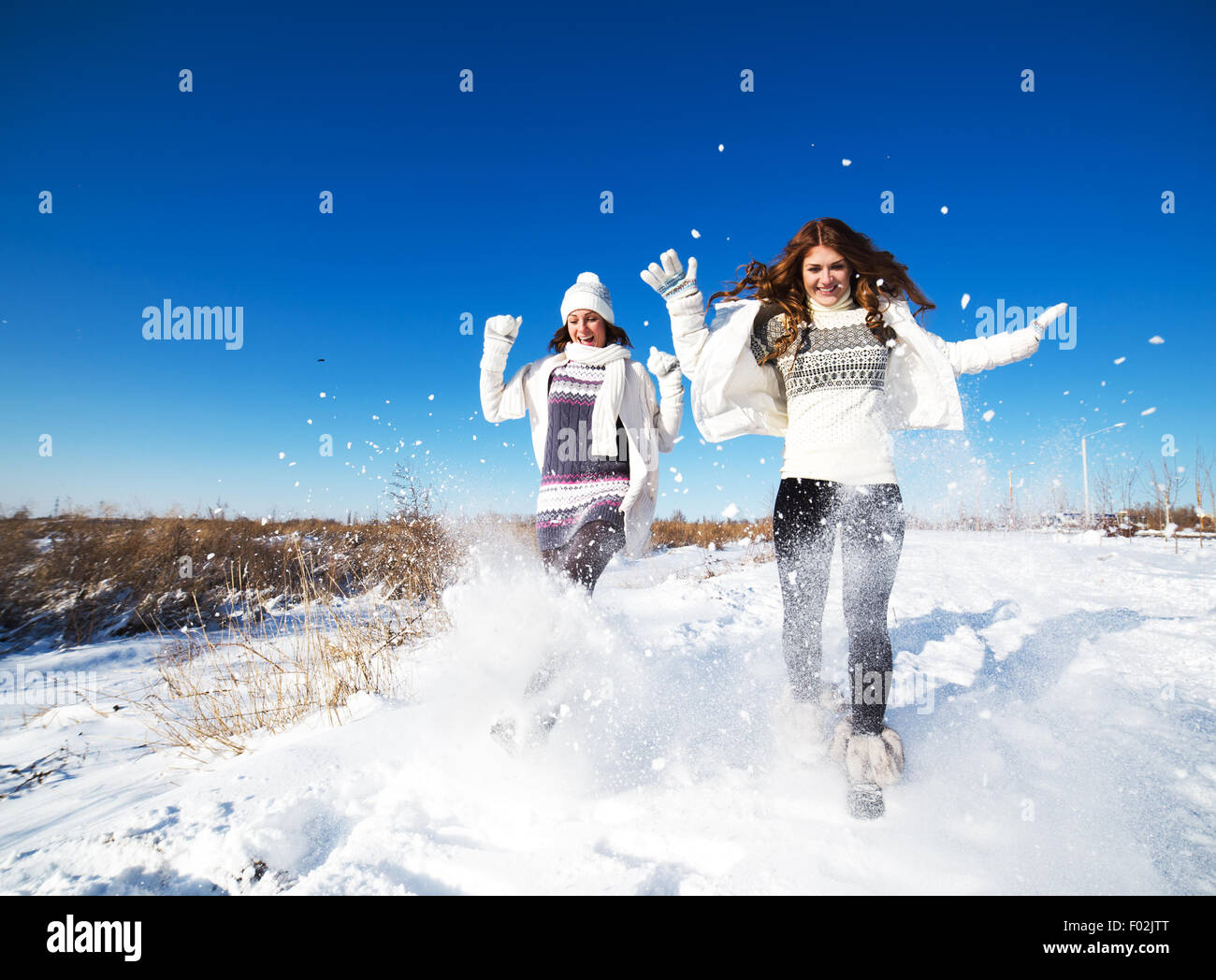 Deux copines s'amuser et profiter de la neige fraîche à la belle journée d'hiver Banque D'Images