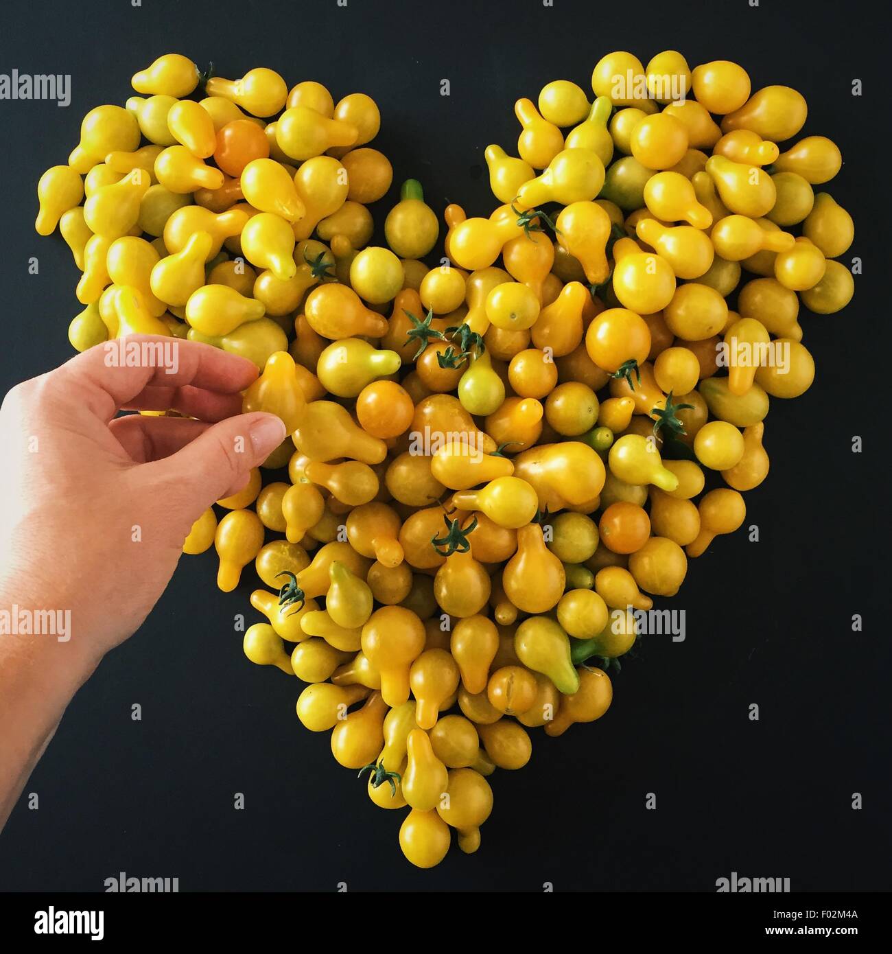 Part de prendre une forme de coeur avec des tomates cerises Banque D'Images