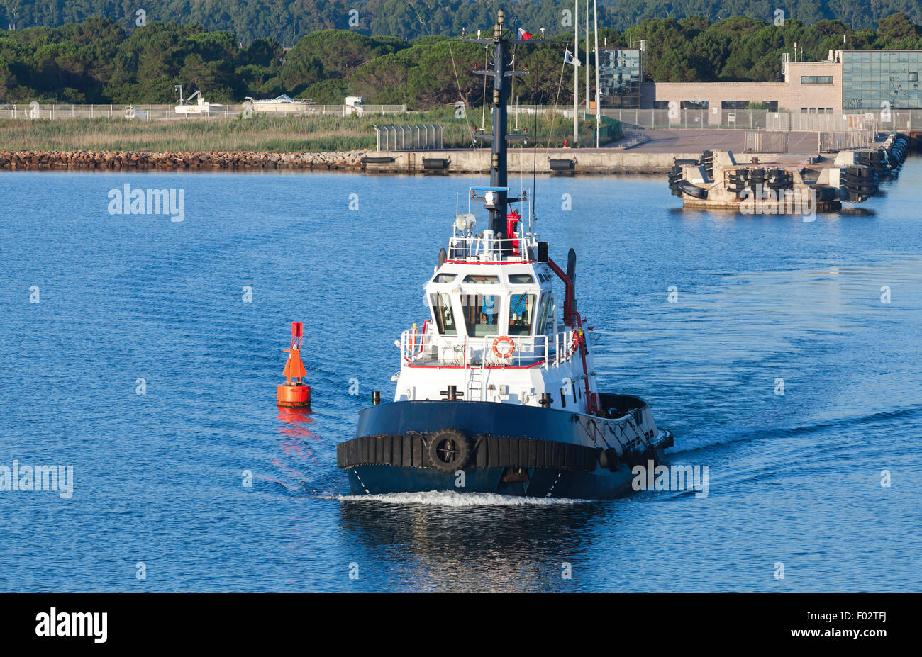 Tug boat avec superstructure blanc et bleu foncé coque va sur un fairway à Porto-Vecchio, Corse, l'île harbour France Banque D'Images