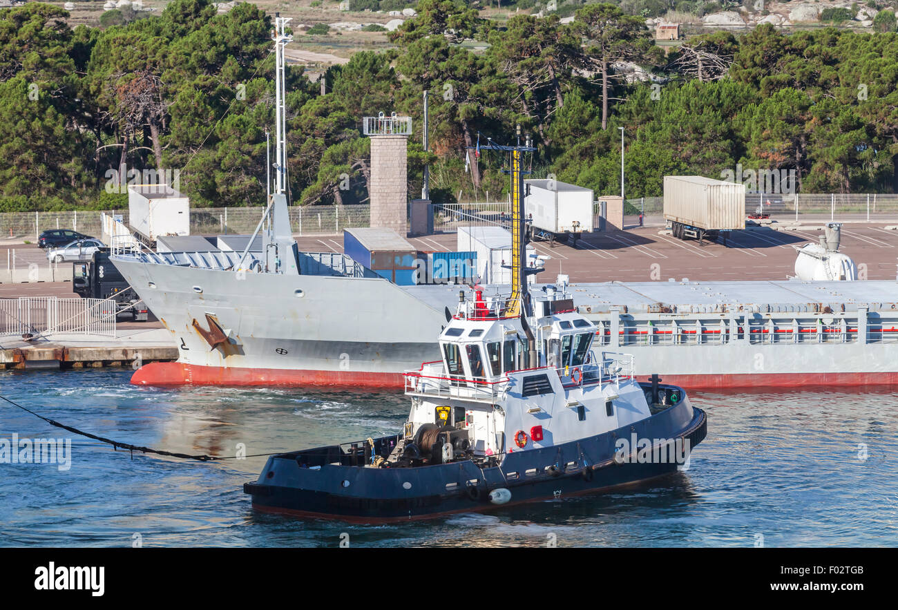 Petit bateau remorqueur avec superstructure blanc et bleu foncé coque travaille à port Banque D'Images