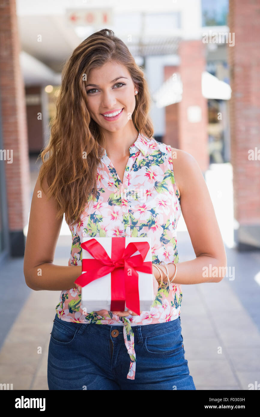 Portrait of smiling woman showing boîte-cadeau à l'appareil photo Banque D'Images