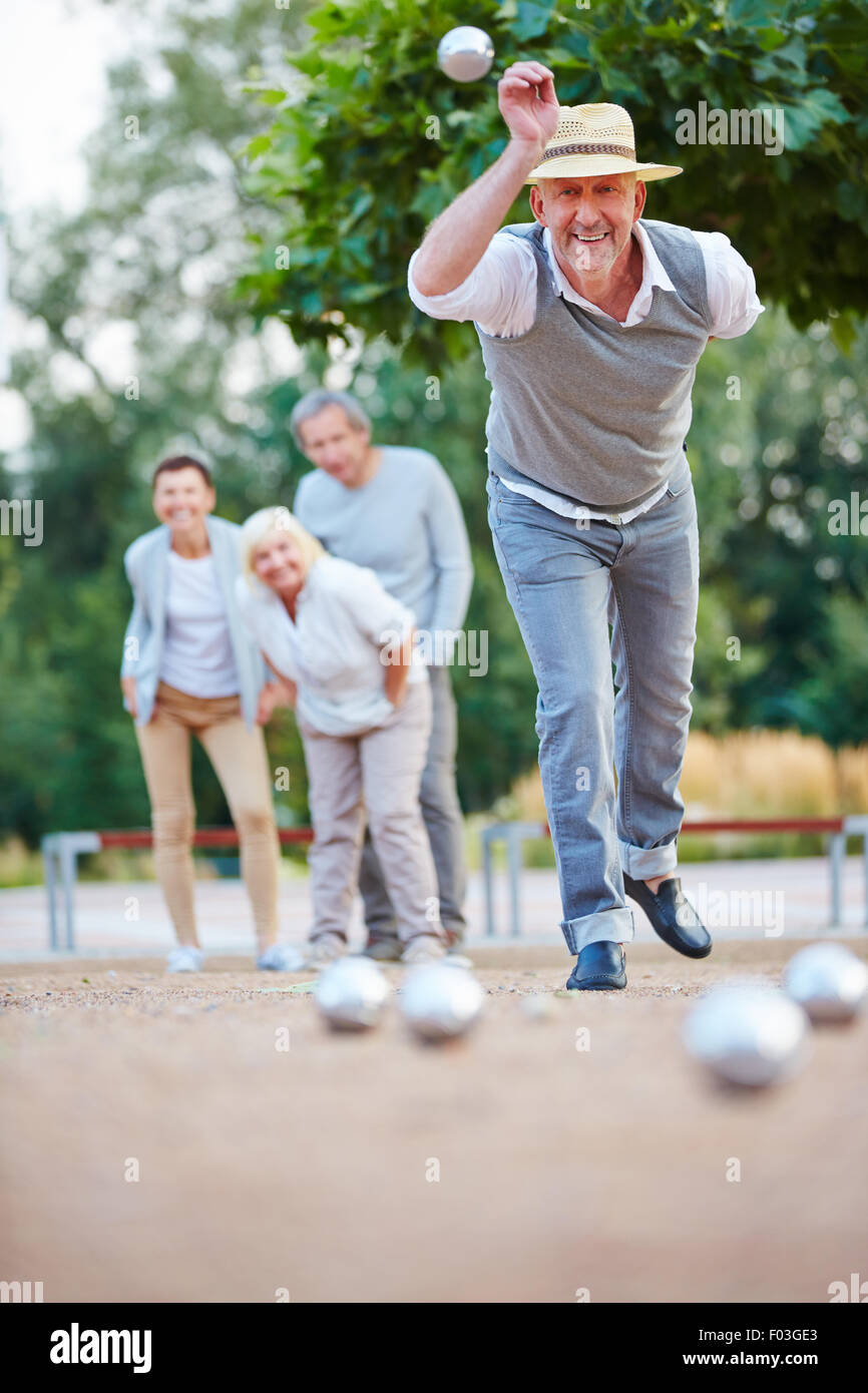 Man throwing ball boule tout en jouant à l'extérieur dans une ville Banque D'Images