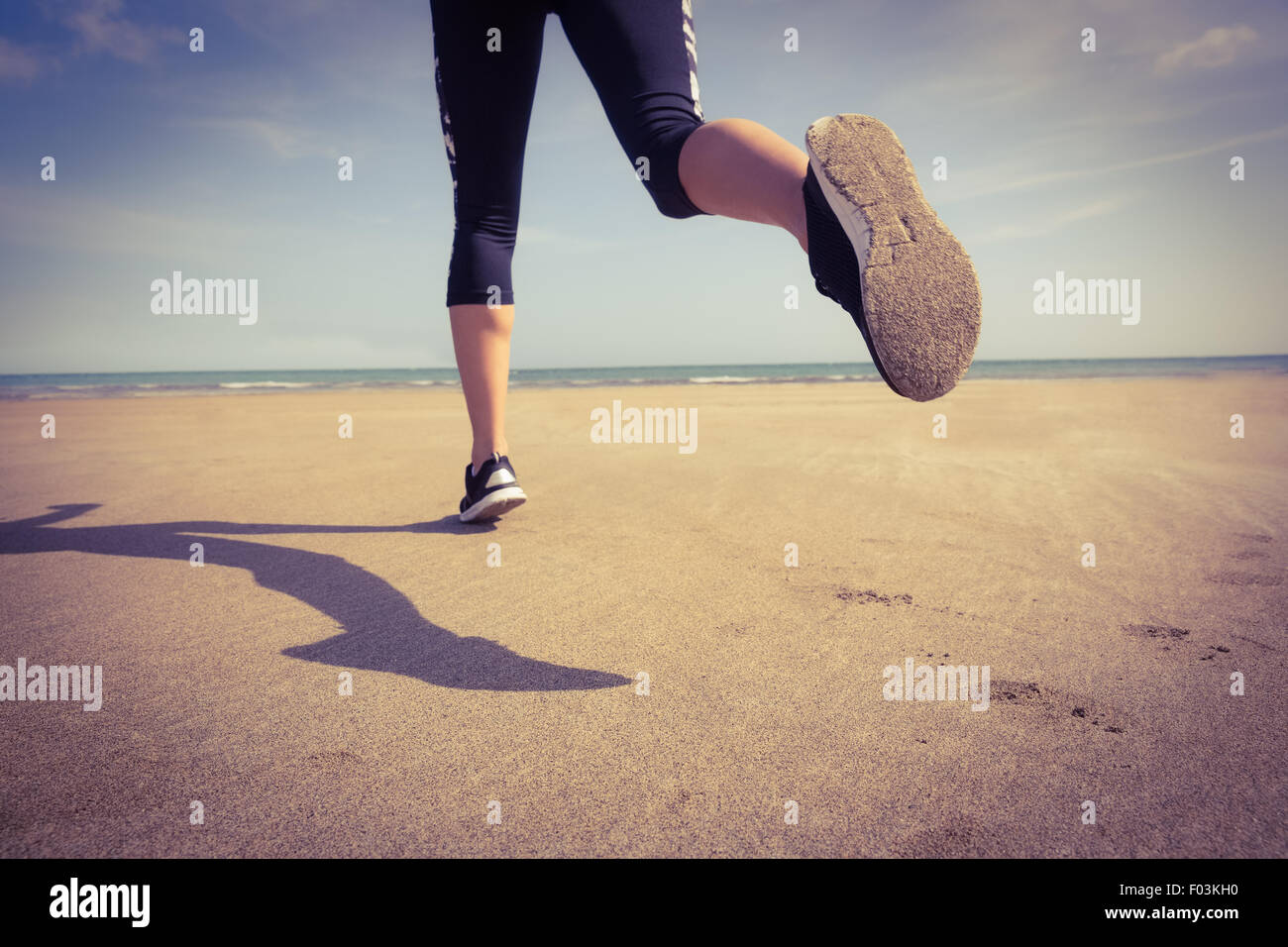 Fit woman jogging sur le sable Banque D'Images