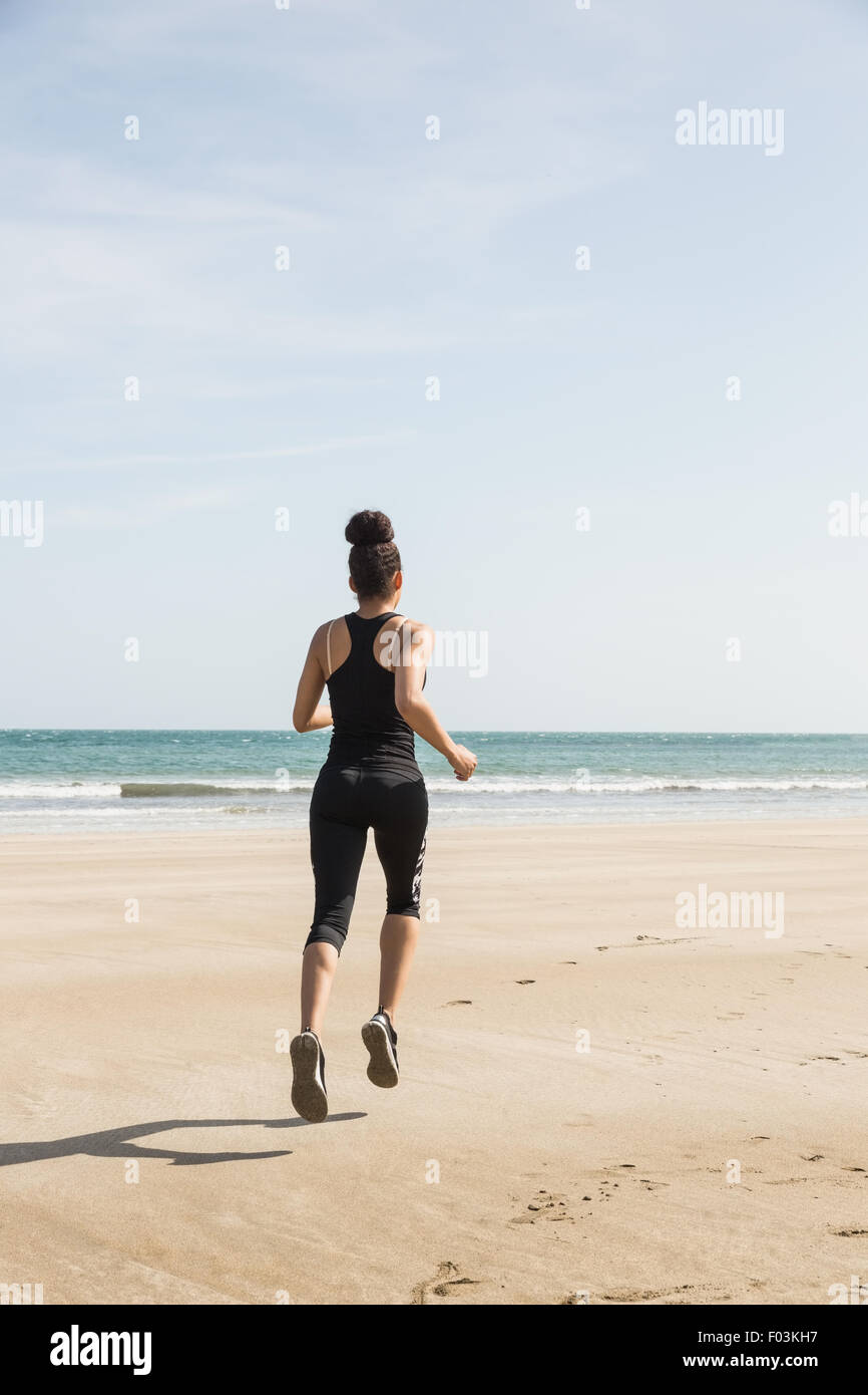 Fit woman jogging sur le sable Banque D'Images