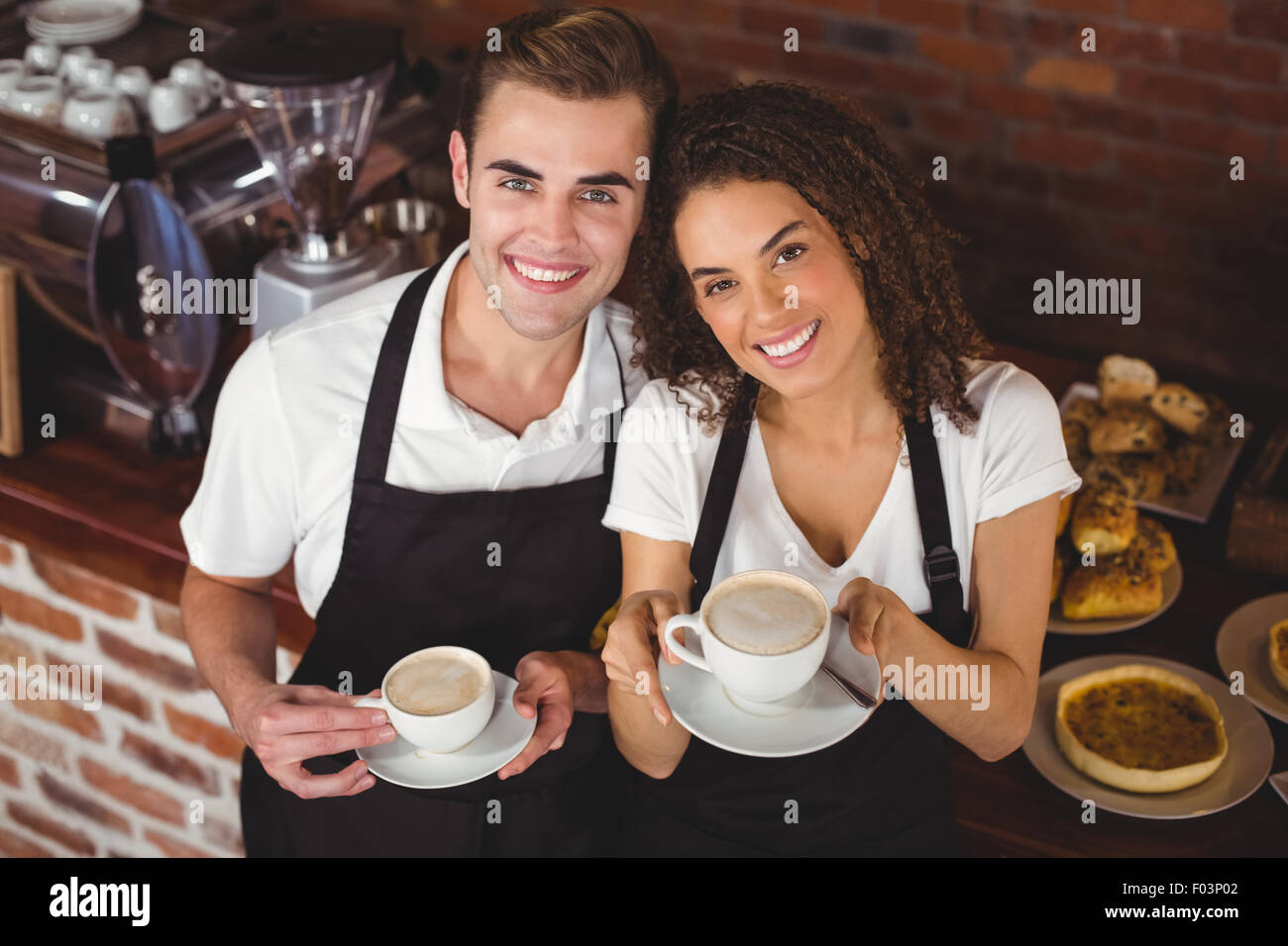 Smiling waiter waitress holding et tasse de café Banque D'Images