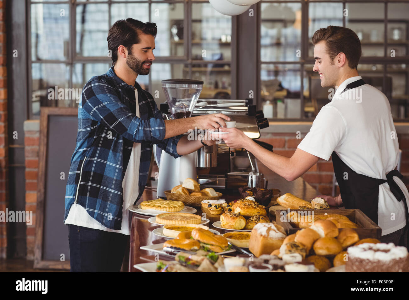 Smiling hipster se tasse de café barista Banque D'Images