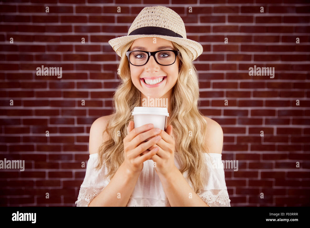 Gorgeous smiling blonde hipster avec tasse à emporter Banque D'Images