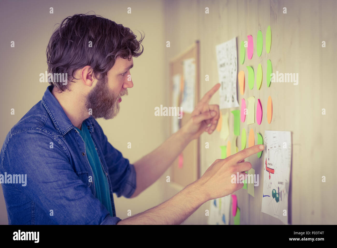 Hipster barbu à réfléchir au mur Banque D'Images