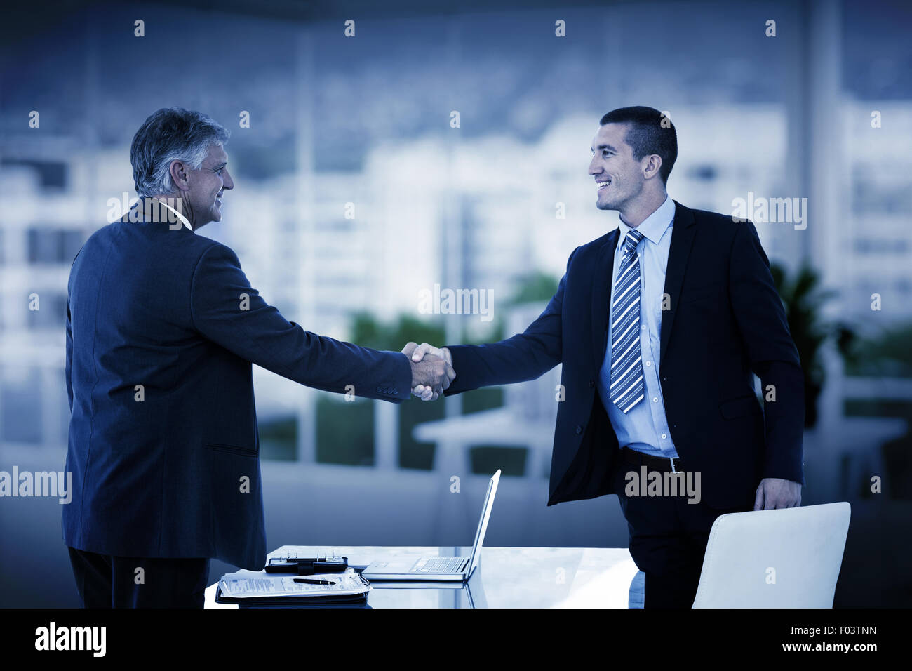 Image composite de businessmen shaking hands Banque D'Images