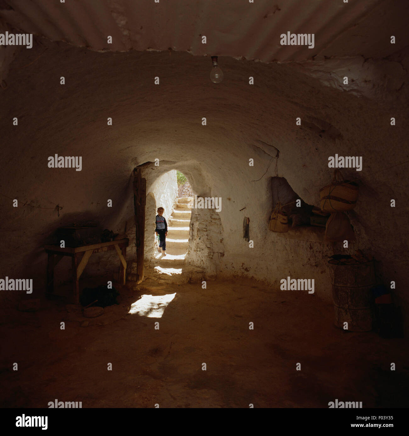Jeune garçon à la porte d'une habitation troglodytique, Matmata, Tunisie. Banque D'Images