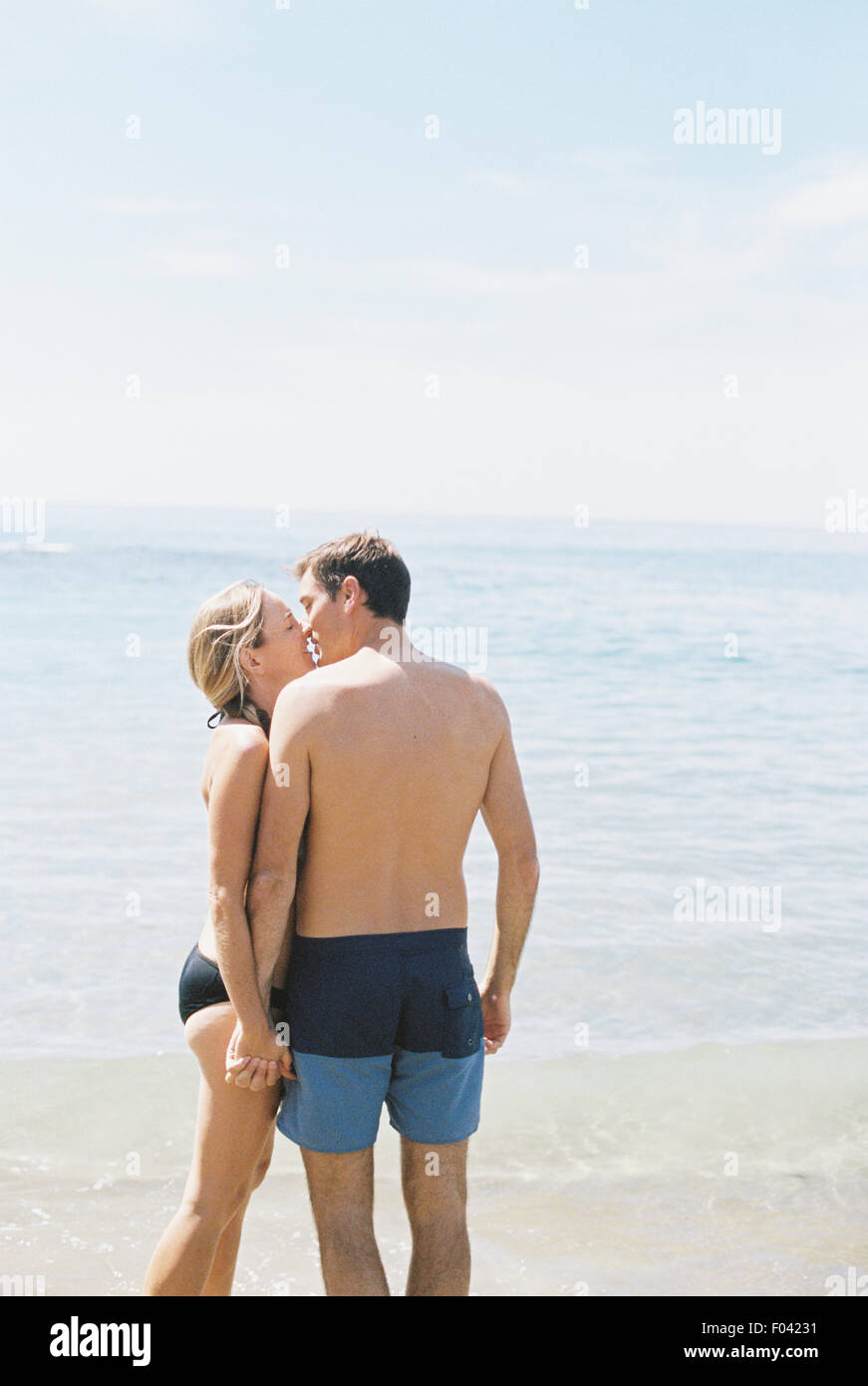 Couple en maillot de bain sur une plage de sable fin à l'océan, s'embrasser  Photo Stock - Alamy