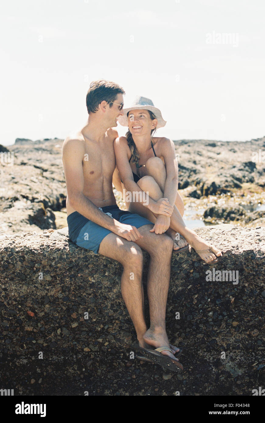 Un homme et une femme, un couple assis sur la plage à l'autre avec amour Banque D'Images