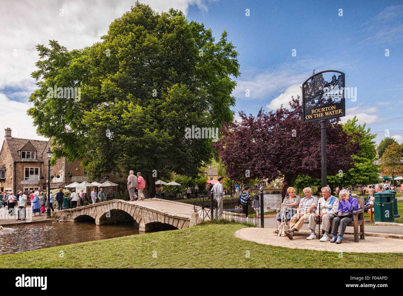 Les touristes profiter d'après-midi d'été dans le village de Cotswold Bourton-on-the-water, Gloucestershire, Angleterre. Banque D'Images