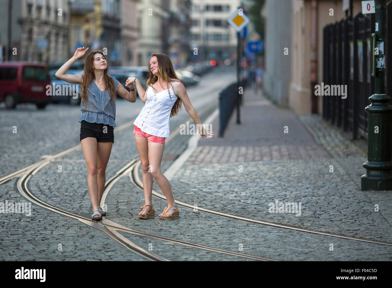 Funny teen girls ensemble marcher sur la chaussée sur la rue. Banque D'Images