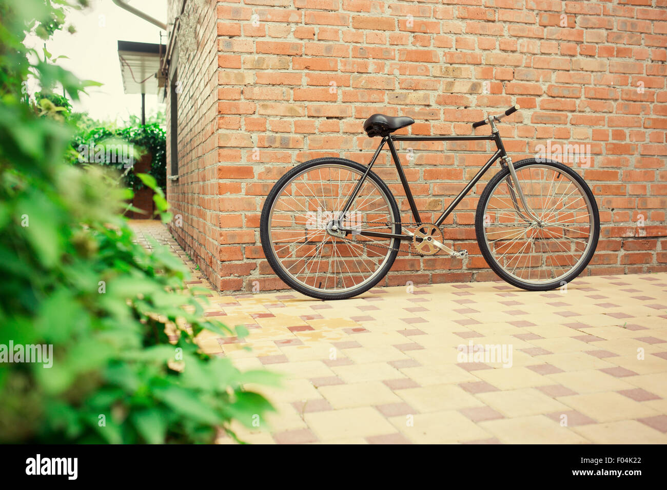 Old style singlespeed vélo contre un mur de briques, photo teinté Banque D'Images