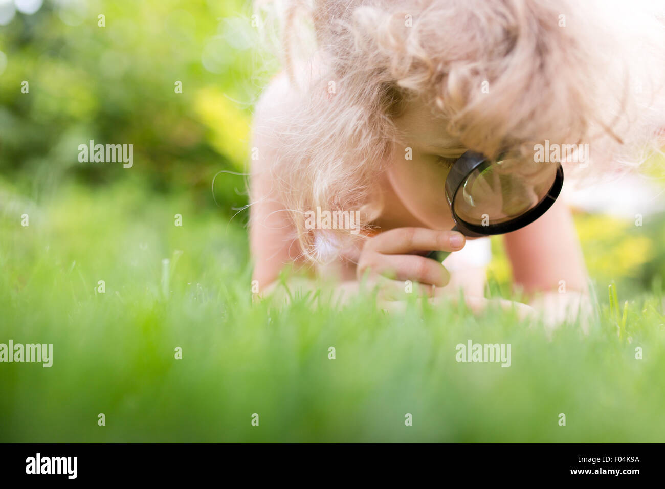 Petite fille explorer la nature avec une loupe Banque D'Images