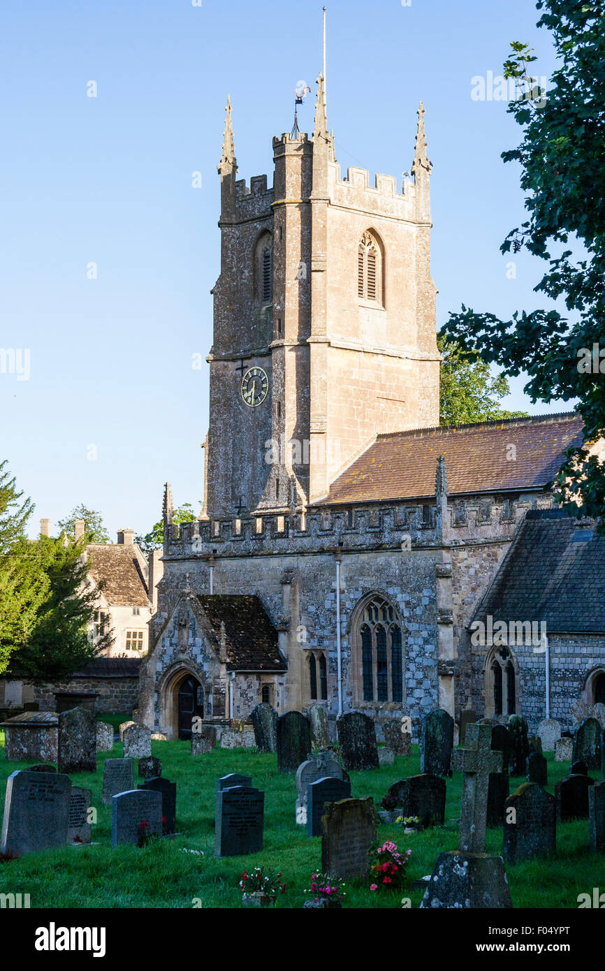 Village d'Avebury, Saint James Church, principalement 1300 mais les pièces datant de 1000 AD avec Norman ajouts. Cimetière de l'église en premier plan. Ciel bleu. Banque D'Images