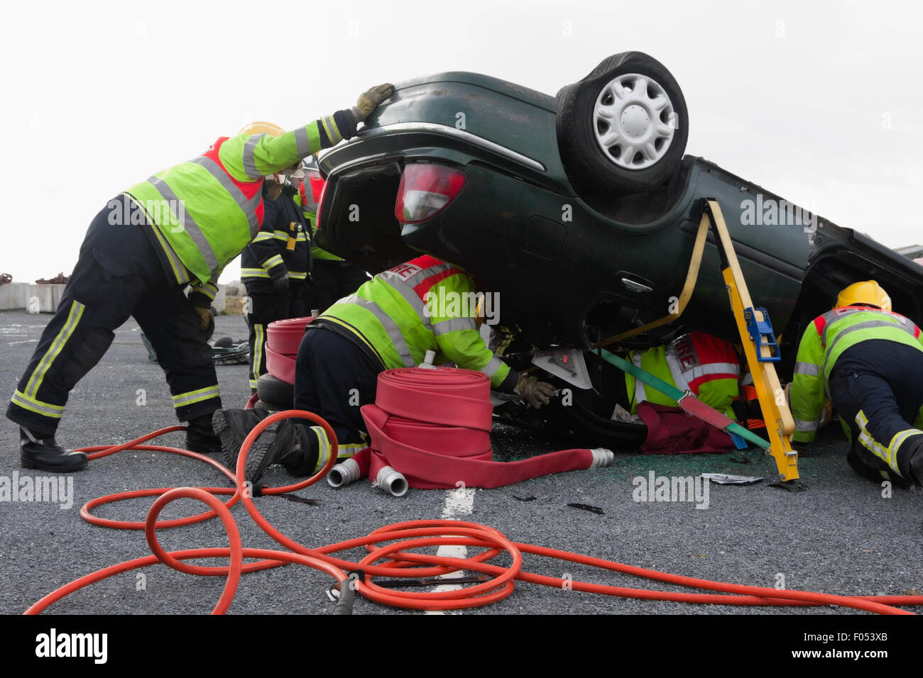 Unités d'urgence d'incendie et de sauvetage en action à l'accident de voiture Banque D'Images