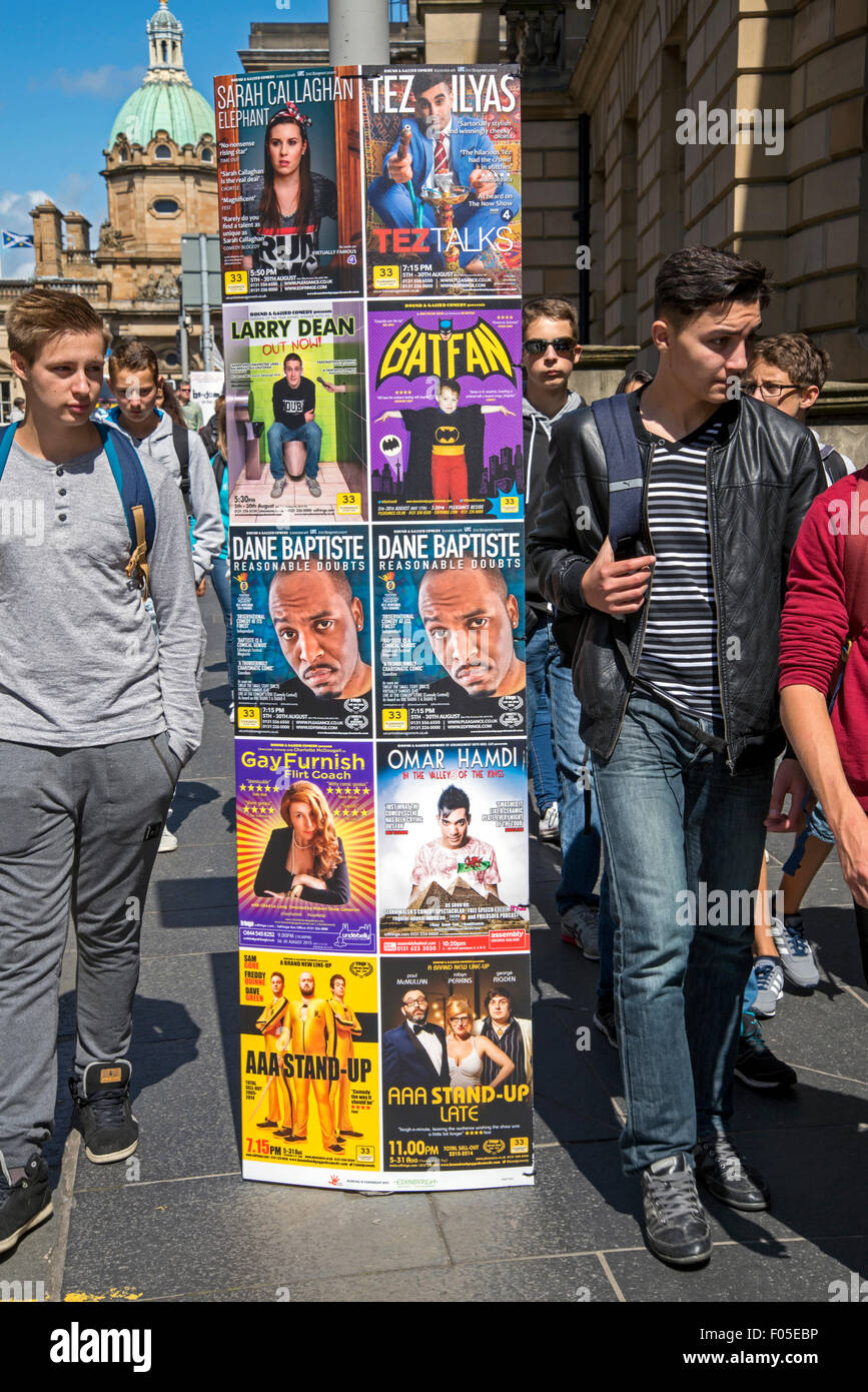 Les jeunes touristes masculins sur George IV Bridge à Edburgh marcher par annonces de spectacles sur l'Edinburgh Fringe Festival. Banque D'Images