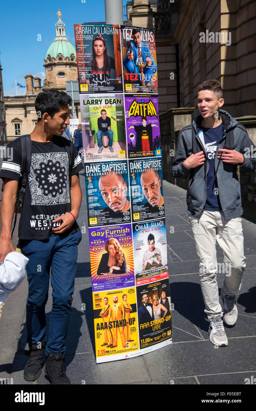 Les jeunes touristes masculins sur George IV Bridge à Edburgh marcher par annonces de spectacles sur l'Edinburgh Fringe Festival. Banque D'Images