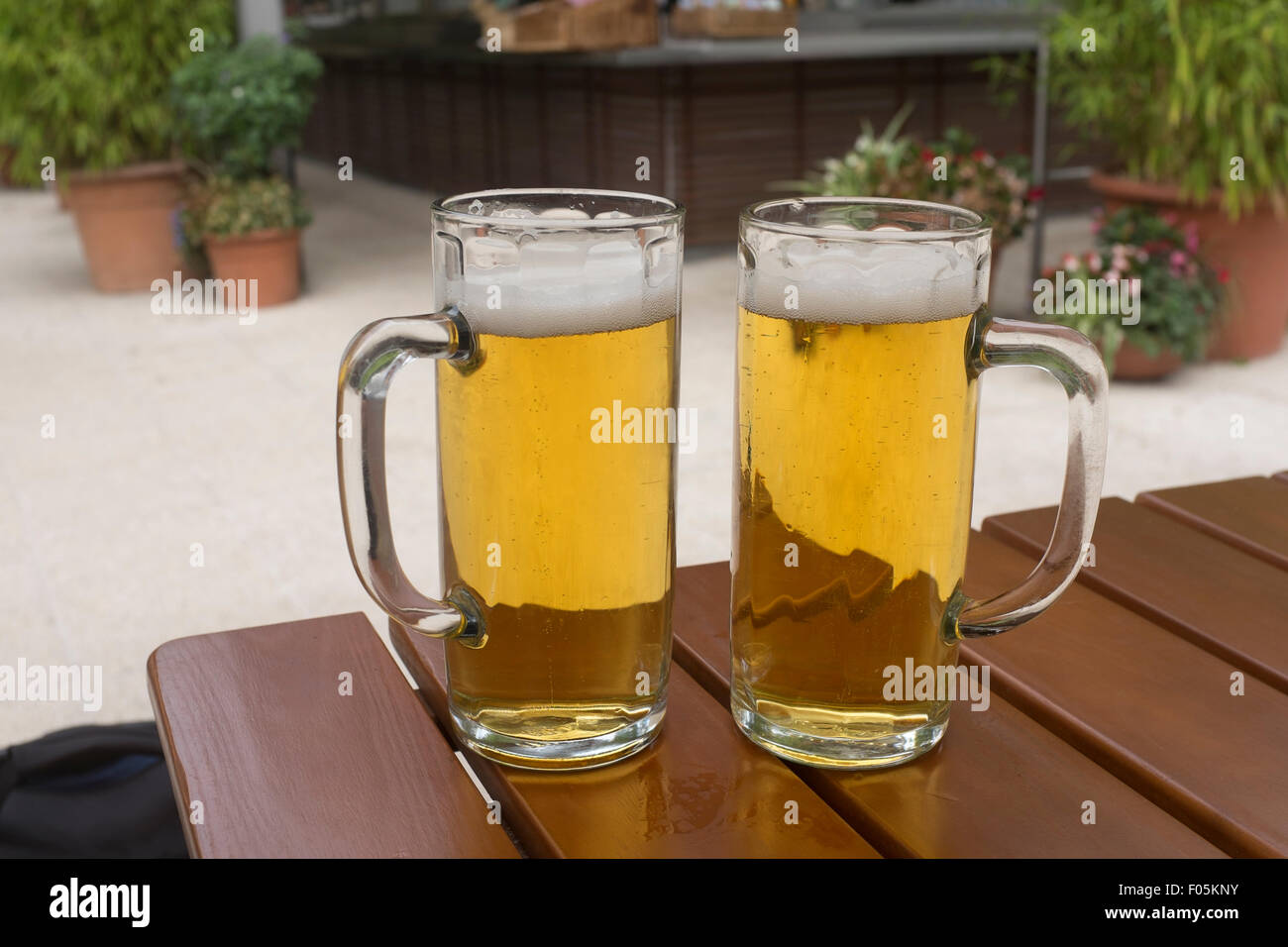 Deux demi-litres de bière Pilsner helles sur une table dans un biergarten, Allemagne Banque D'Images
