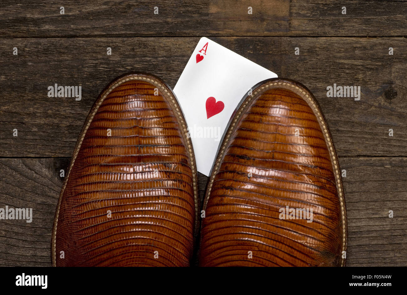 Joueur de poker à la tricherie main sous boot cowboy. Banque D'Images