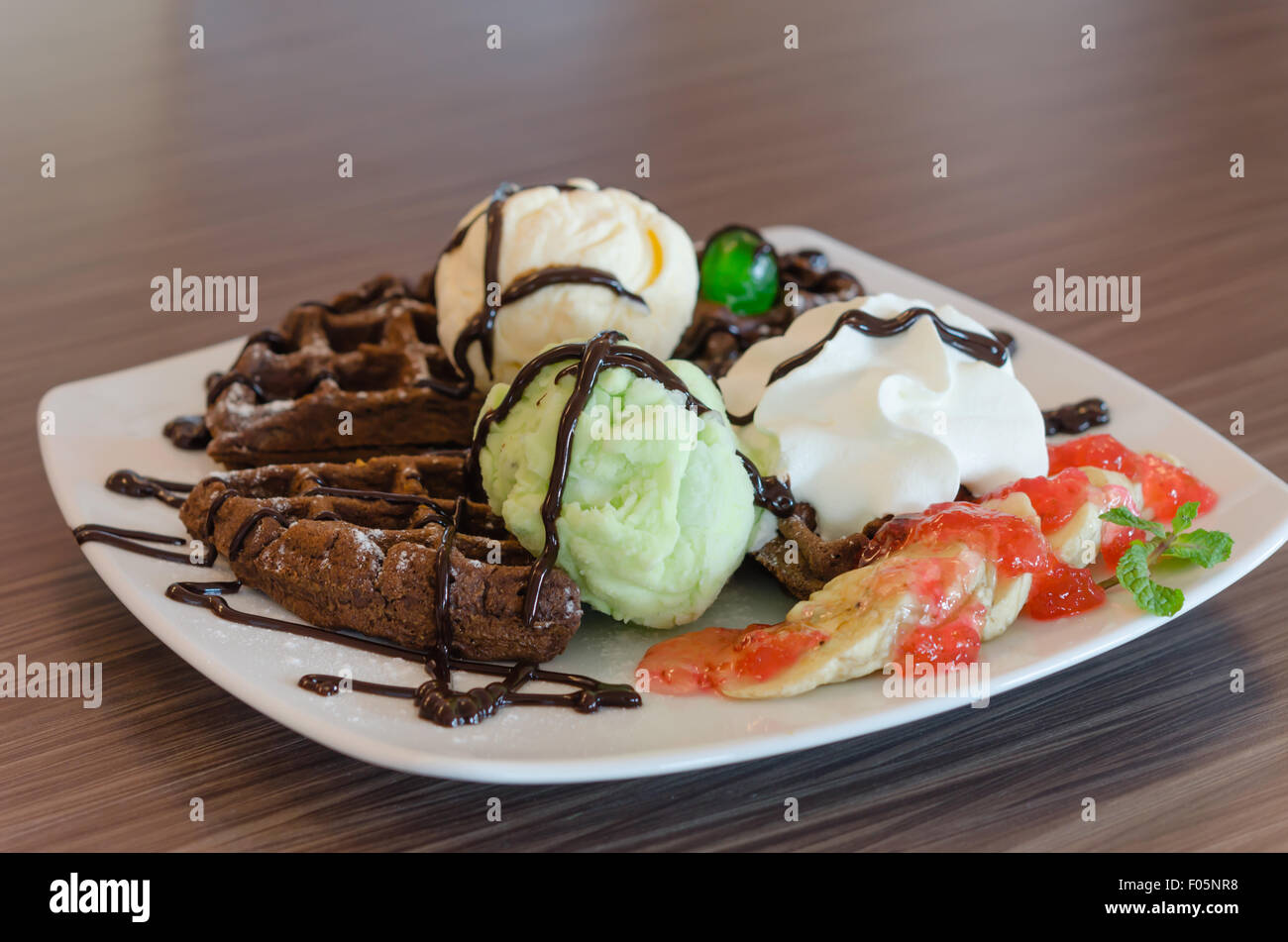 Crème glacée , gaufres au chocolat avec sauce au chocolat et crème fouettée Banque D'Images