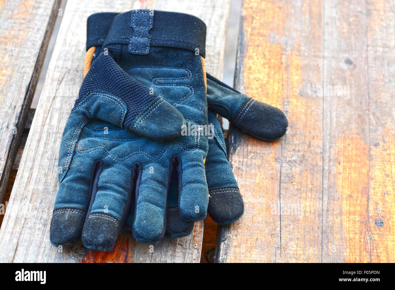 Paire de gants en cuir noir travailler sur une table en bois Banque D'Images