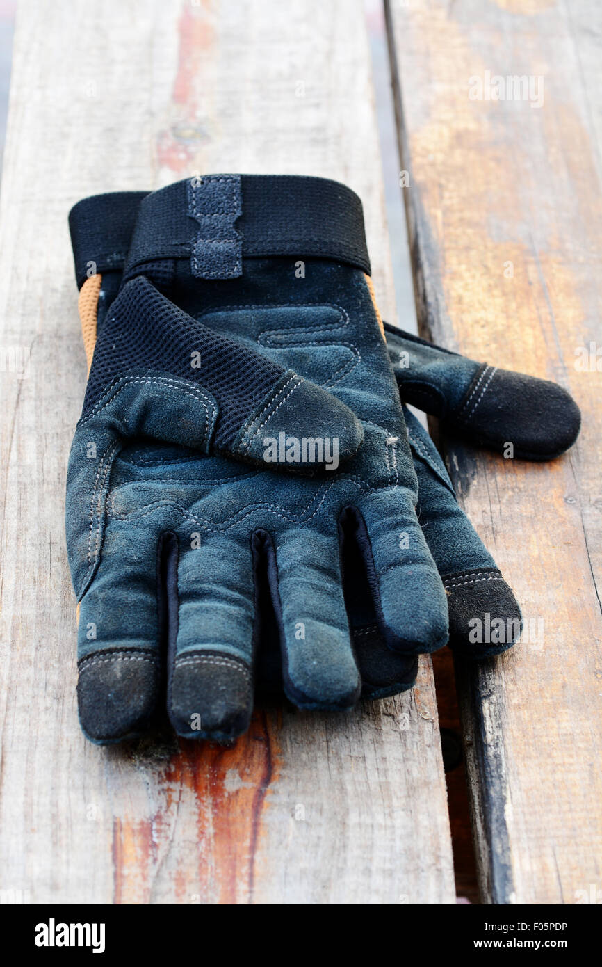 Paire de gants en cuir noir travailler sur une table en bois Banque D'Images