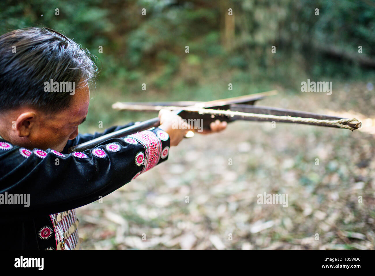 Le tournage d'un homme Hmong hand made arbalète dans un village de Chiang Mai, Thaïlande, Asie. Banque D'Images