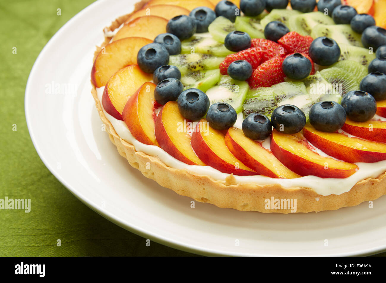 Près d'un délicieux gâteau de couche avec garnitures de fruits frais servis sur une plaque ronde blanche. Banque D'Images