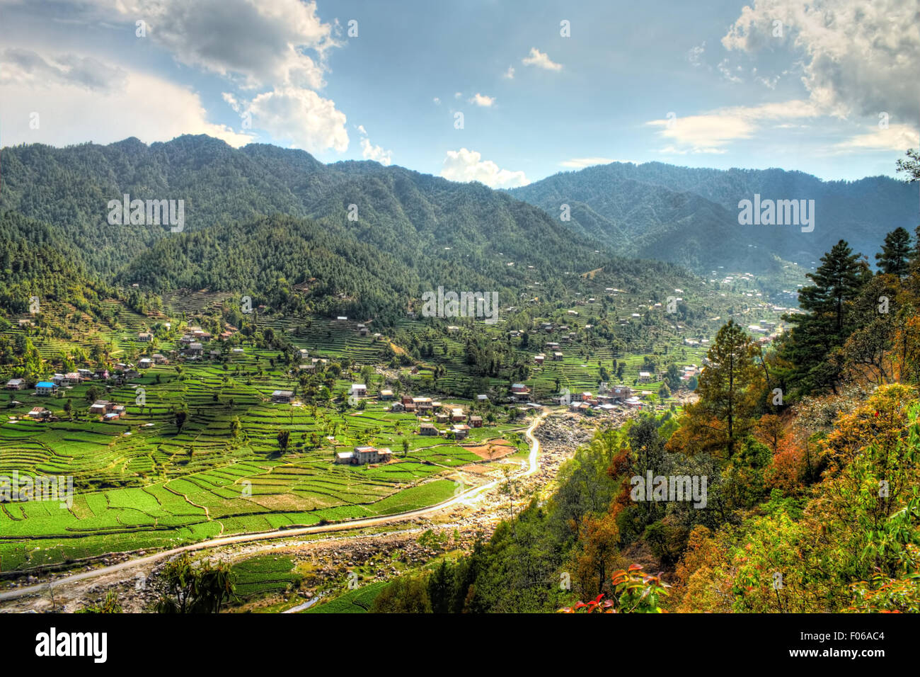 Maisons dans la colline népalais d'une journée ensoleillée avec des nuages intermittents Banque D'Images