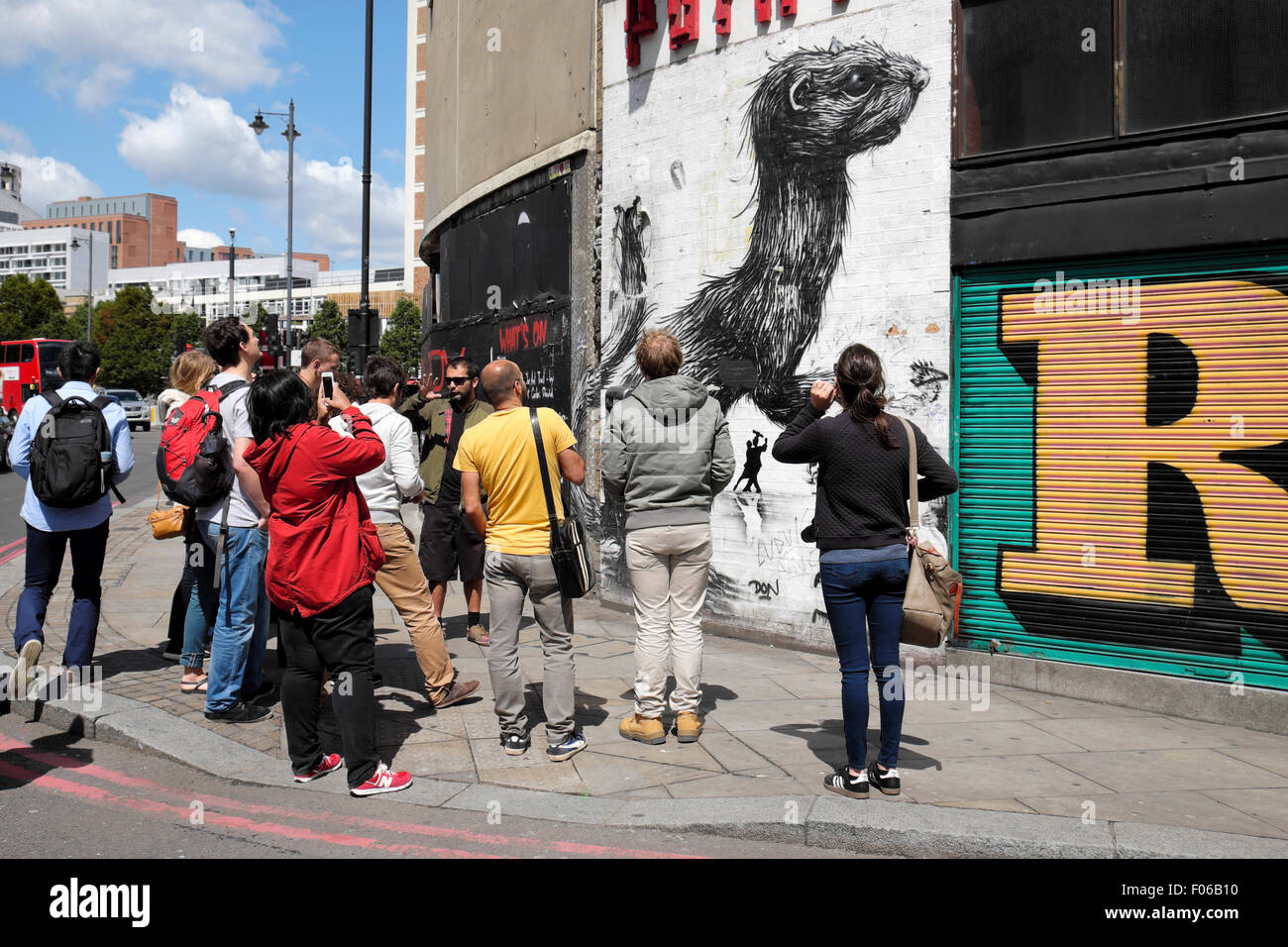 Groupe de Street Art et guide regardant les graffitis sur un mur près de Rivington Street à Shoreditch est de Londres Angleterre britannique KATHY DEWITT Banque D'Images