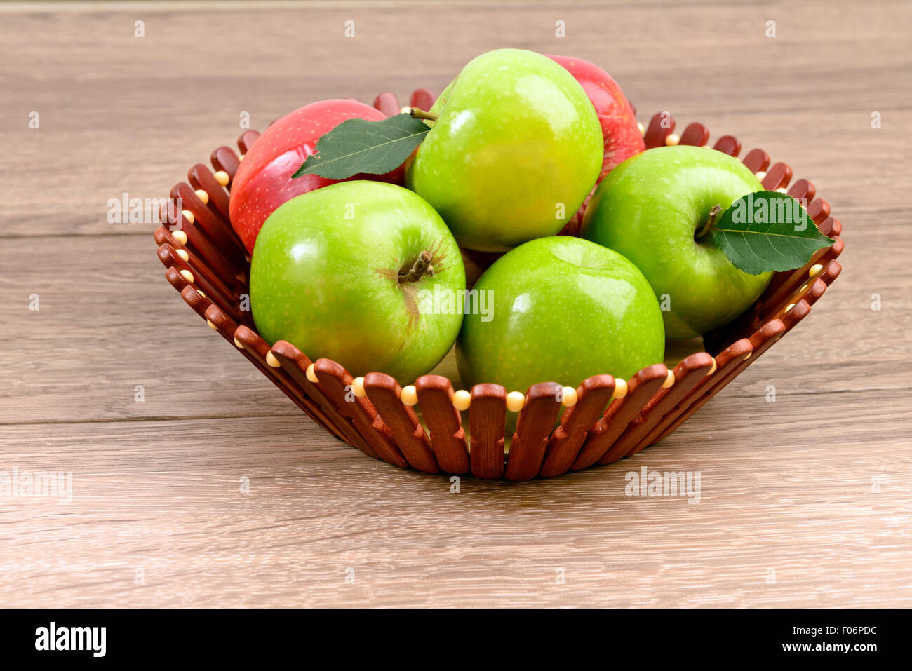 Les pommes dans le panier sur fond de bois brun Banque D'Images