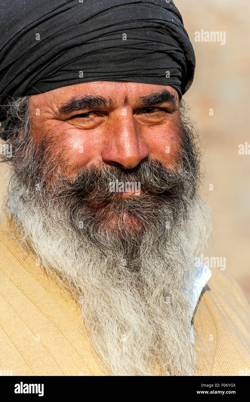 Le punjabi man smiling avec turban noir et une barbe grisonnante merveilleux Banque D'Images