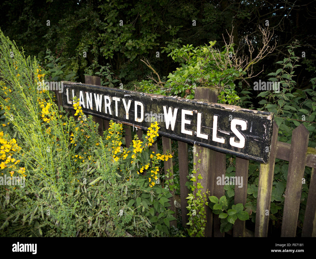 Nom ancien panneau à l'entrée de la Gare à Llanwrtyd Wells, Powys, Mid Wales Banque D'Images