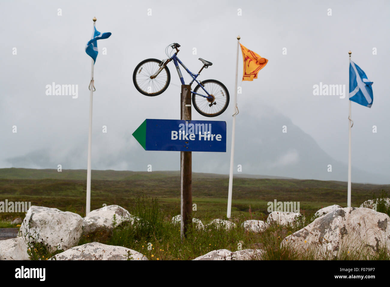 Location de vélo panneau à l'entrée de Glencoe Mountain Resort, Glencoe, Écosse, Royaume-Uni, avec couvert de nuages Buachaille Etive Mor derrière Banque D'Images
