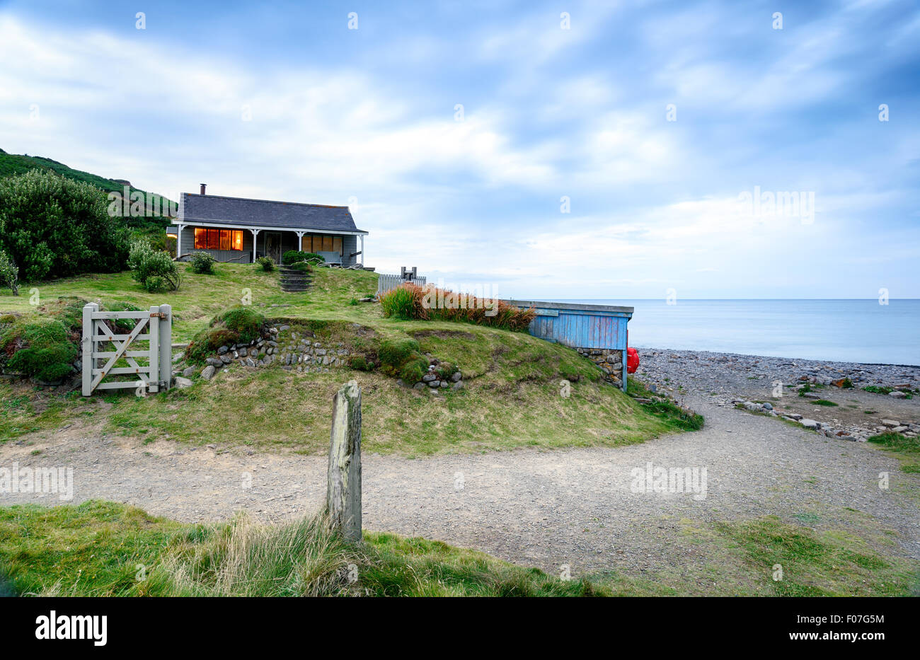 Crépuscule sur une maison sur la plage à Millook Haven près de Bude sur la côte de Cornouailles Banque D'Images