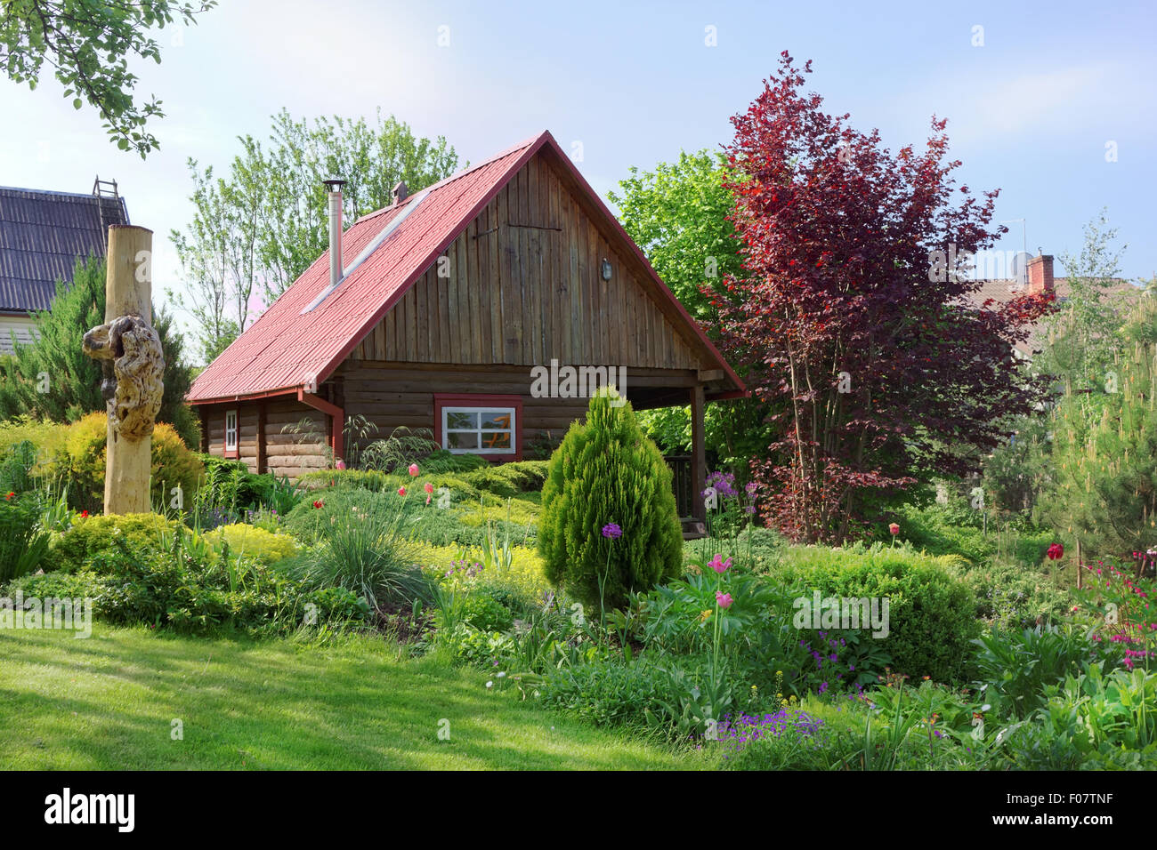 Dans Europeanl baignoire rural village jardin avec une pelouse verte, fleurs et arbustes. Paysage d'été ensoleillée le jour Banque D'Images