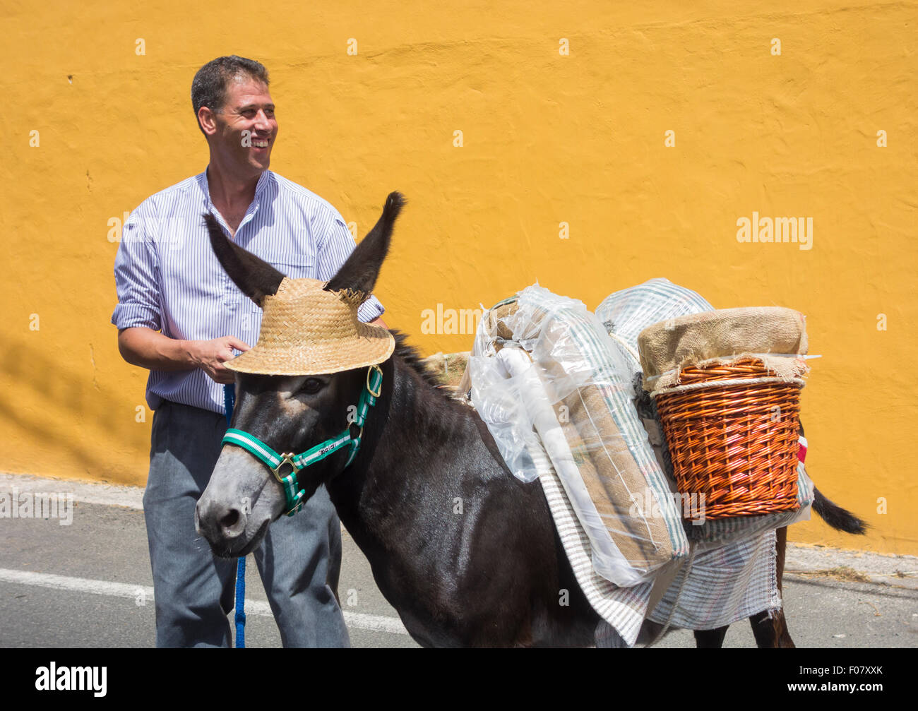 Lomo Magullo, Gran Canaria, Îles Canaries, Espagne. 09Th Aug 2015. Traida del Agua ( mettre de l'eau) fiesta en 7343 Magullo village sur Gran Canaria. Sur la photo : deux hommes en costume traditionnel et de l'Âne avec chapeau de paille obligatoire inscrivez-vous à la procession de la place du village. Credit : ALANDAWSONPHOTOGRAPHY/Alamy Live News Banque D'Images