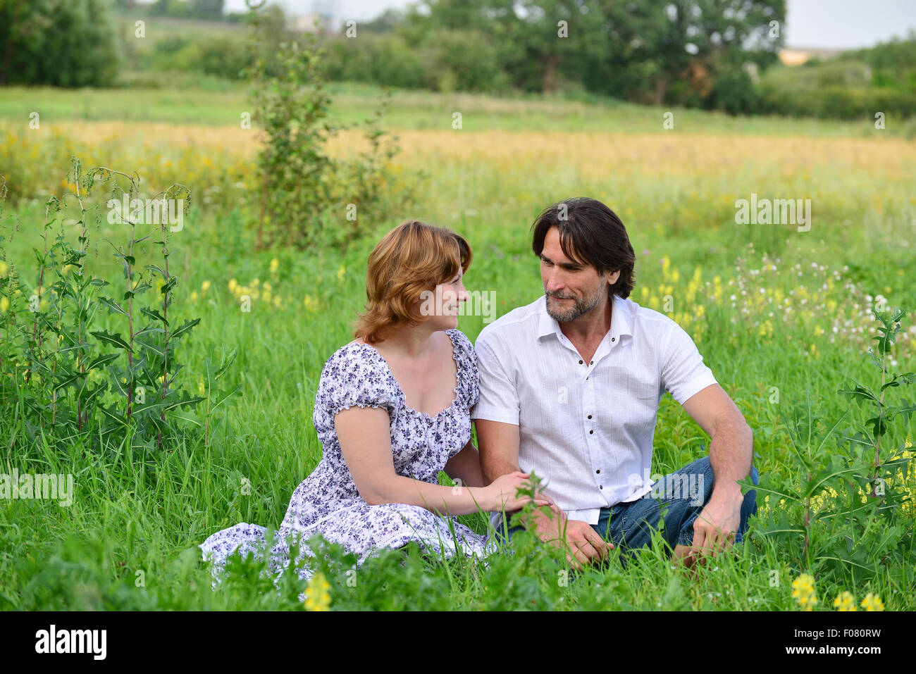 Un couple d'amoureux se détendre sur un pré Banque D'Images