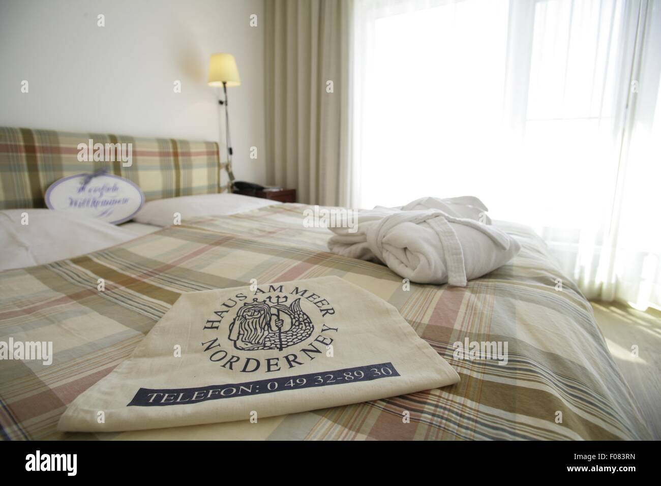 Chambre avec porte-serviettes chauffant et le couvercle sur le lit dans l'hôtel Haus am Meer, Norderney, Allemagne Banque D'Images