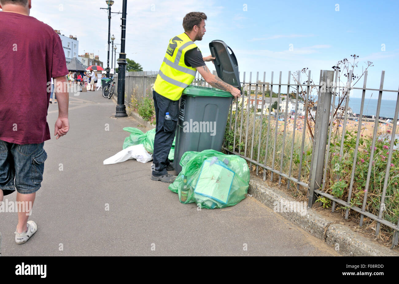 Broadstairs, Kent, Angleterre, Royaume-Uni. Homme vidange d'un bac de litière sur le front de mer Banque D'Images