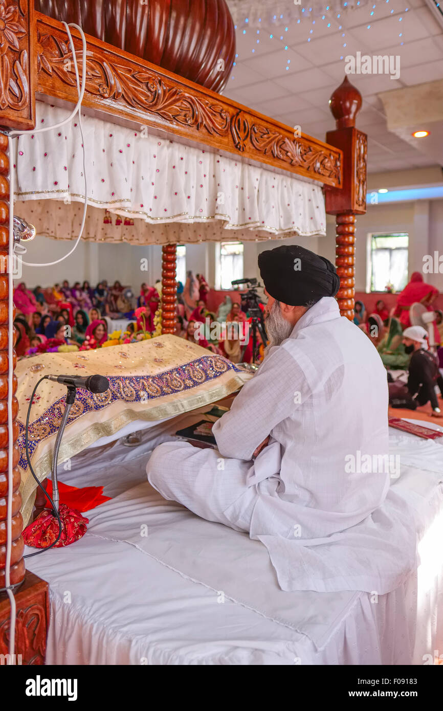 Prêtre assis à Vigil à Brent Cross avec Temple Sikh Guru Granth Sahib livre saint des sikhs Banque D'Images