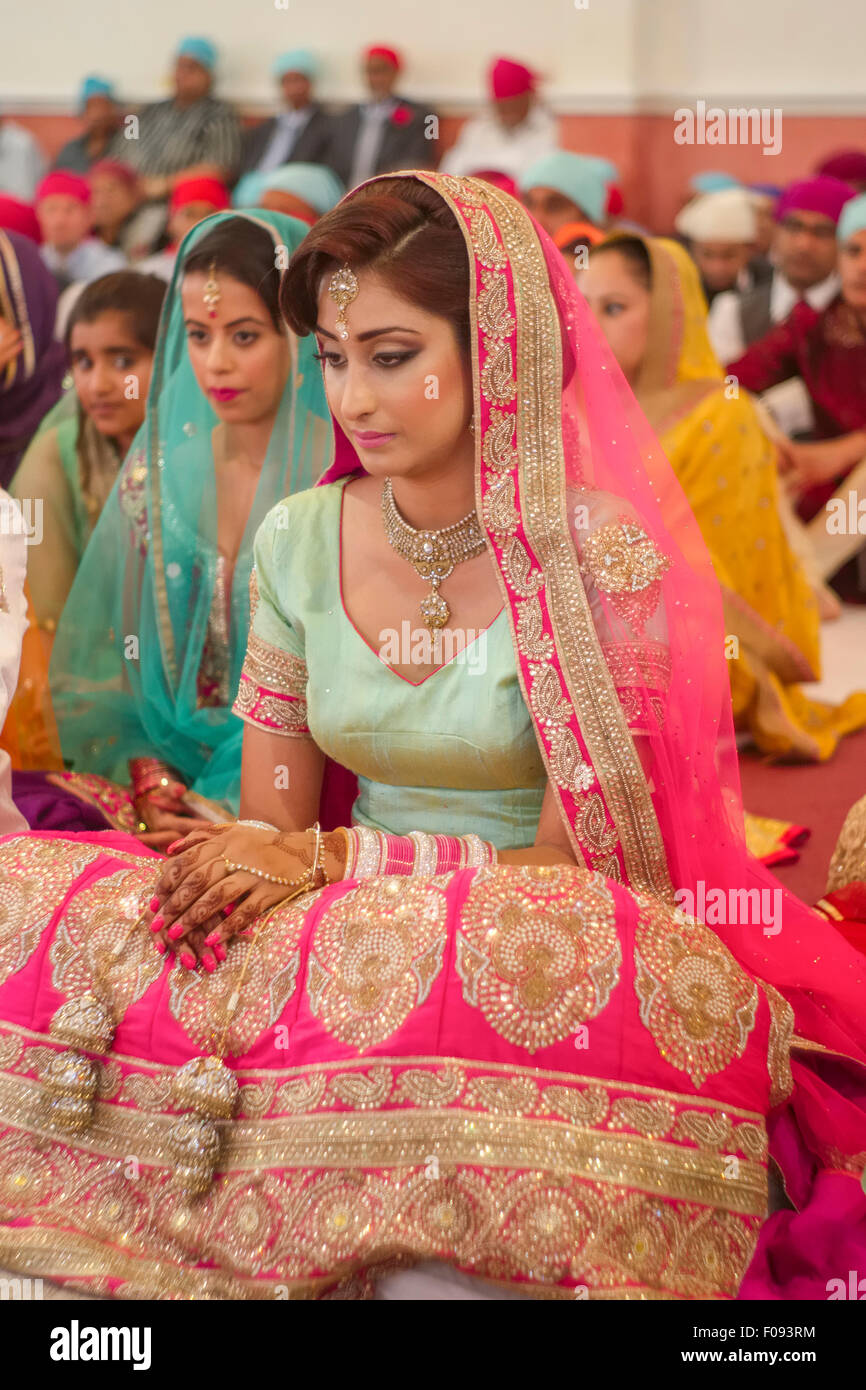 Mariée avec des invités et sikh famille à la cérémonie de mariage Gurdwara Banque D'Images